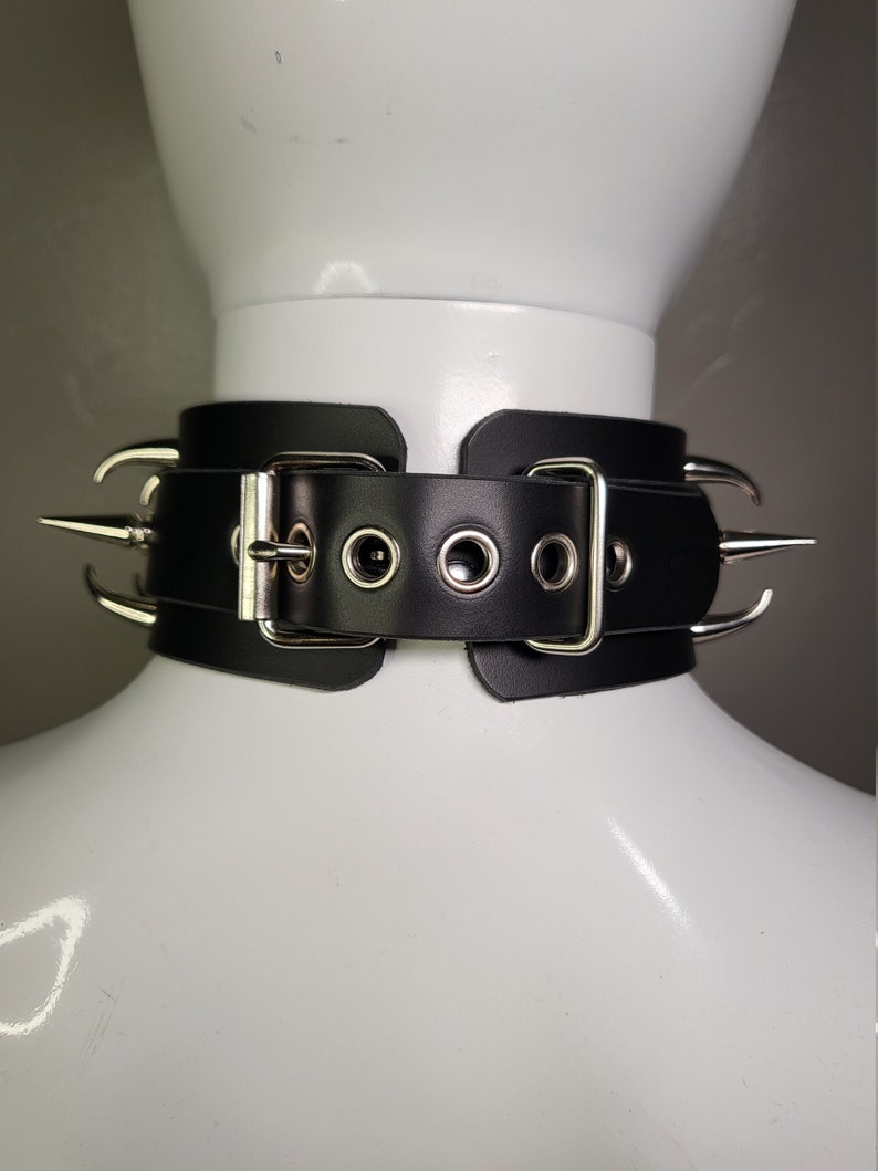 May include: Black leather choker with silver metal spikes and a buckle closure.