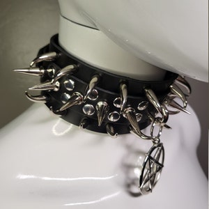 May include: A black leather choker with silver spikes and a pentagram charm.