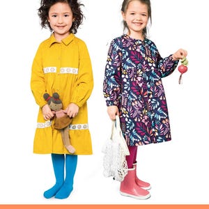 Könnte beinhalten: Zwei junge Mädchen in Kleidern. Eines trägt ein senfgelbes Kleid mit weißem Besatz und blauen Strumpfhosen, das eine Puppe hält. Das andere hat ein Kleid mit Blumenmuster, rosa Stiefel und hält eine Radieschen. Der Text unten lautet "Listing is for sewing pattern only."