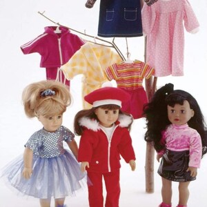 Könnte beinhalten: Nähmuster zum Nähen von Puppenkleidung. Das Muster enthält eine Vielzahl von Outfits, darunter ein rosa Kleid, ein blaues Jeans-Overallkleid, eine rote Jacke, eine gelbe Robe, ein gestreiftes Hemd und ein rosa Pullover. Das Muster wird mit drei Puppen gezeigt, die einige der Outfits tragen.