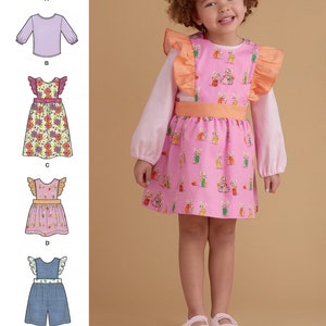 May include: A sewing pattern for a child's dress with a ruffled bib and a matching top. The dress is pink with a print of bunnies riding bicycles. The top is pink with long sleeves. The pattern includes five different styles, including a dress with a floral print, a denim overall, and two different tops.