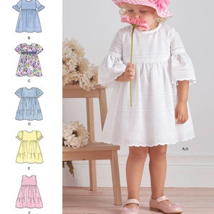 May include: A sewing pattern for a girl's dress with different variations. The pattern includes a dress in solid blue fabric, a dress with a floral print, a dress with a striped fabric, a dress with a yellow fabric, a dress with a pink fabric, and a dress with a white fabric. The pattern also includes a hat with pink polka dots and a pink flower.