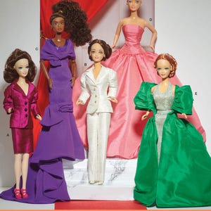 May include: Five Barbie dolls wearing different formal outfits. The dolls are standing on a marble-like surface with a red carpet in the foreground. The dolls are wearing a purple gown, a white suit, a pink gown, a green gown, and a red suit.