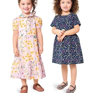 Könnte beinhalten: Zwei junge Mädchen in Kleidern. Ein Kleid ist rosa mit gelben Blumenmustern, das andere ist marineblau mit Blumenmuster. Die Kleider haben kurze Ärmel und sind knielang. Der Text unten lautet "Listing is for sewing pattern only."
