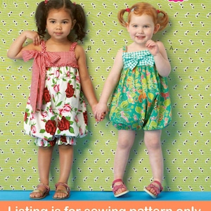 May include: Sewing pattern for two girls' dresses. One dress is red and white with a floral print and a red and white gingham bow. The other dress is green and white with a floral print and a green and white gingham bow. The pattern number is K174.