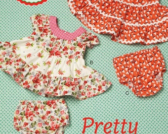 May include: A sewing pattern for a baby dress and bloomers by Ellie Mae Designs, labeled K198 and Pretty Baby. The pattern features two variations: one with a red and white sailboat print and another with a floral print on a white background.