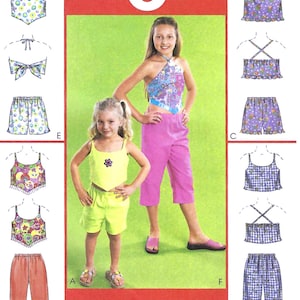 May include: A sewing pattern for six different looks for girls. The pattern includes a halter top, a tank top, a pair of shorts, and a pair of pants. The pattern is called "Great Looks 1 Easy Pattern".