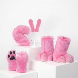 May include: A set of pink faux fur costume accessories including a pair of paw-shaped gloves with black pads and white claws, a pair of furry boot covers, a plush tail, and a headband featuring two tall, upright pink rabbit ears.