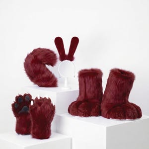 May include: A set of deep burgundy faux fur accessories including a pair of paw-shaped gloves with white claws, a pair of furry boot covers, a long curved tail, and a headband featuring two tall, upright, matching burgundy animal ears.