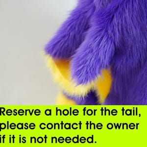 a purple and yellow stuffed animal with a quote on it