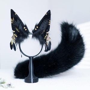 May include: Black faux fur tail and matching ear headband with gold and black accents and dangling feathers.