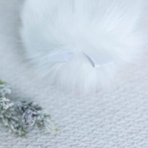 May include: White faux fur headband with a white elastic band.