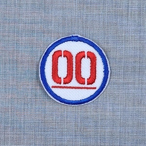 Puede incluir: Un parche circular blanco y azul con un n&uacute;mero "00" bordado en rojo en el centro.