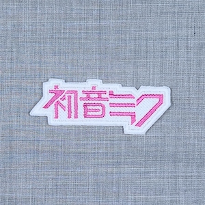 May include: White embroidered patch with the Japanese characters "宿命" in pink.