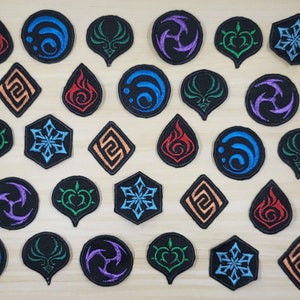 May include: A collection of 20 embroidered iron-on patches featuring various symbols and designs. The patches are in a variety of colors, including blue, green, red, orange, purple, and black. The patches are all circular or hexagonal in shape.