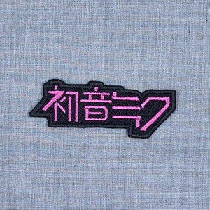 May include: Black and pink embroidered patch with the Japanese text "有言実行" which translates to "Walk the Talk".