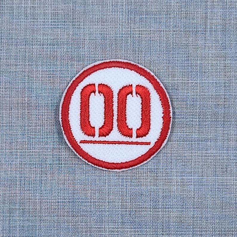 Puede incluir: Parche bordado rojo y blanco con el n&uacute;mero "00" en un c&iacute;rculo.