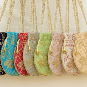 Puede incluir: Colección de ocho bolsas bordadas con cordón en varios colores, incluyendo azul marino, turquesa, rojo, gris, verde, lavanda, blanco roto y beige. Cada bolsa presenta bordados florales dorados y un cordón dorado.