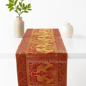 Könnte beinhalten: Roter und goldener Tischläufer mit einem verzierten Muster mit Fabelwesen. Der Läufer ist rechteckig und hat ein detailliertes Design. Der Text "Copyright@Lifelinestore" ist sichtbar.