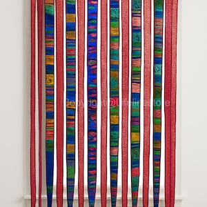 Puede incluir: Una colorida cortina artesanal con rayas verticales. Paneles a rayas rojas, azules y multicolores alternados cuelgan de una barra de madera. Las rayas multicolores presentan tonos verdes, amarillos y azules. La cortina es un tratamiento decorativo para ventanas.