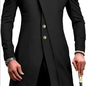 May include: A black long-sleeved suit jacket with a mandarin collar and gold buttons. The jacket has a unique asymmetrical design with a single button closure on the front.