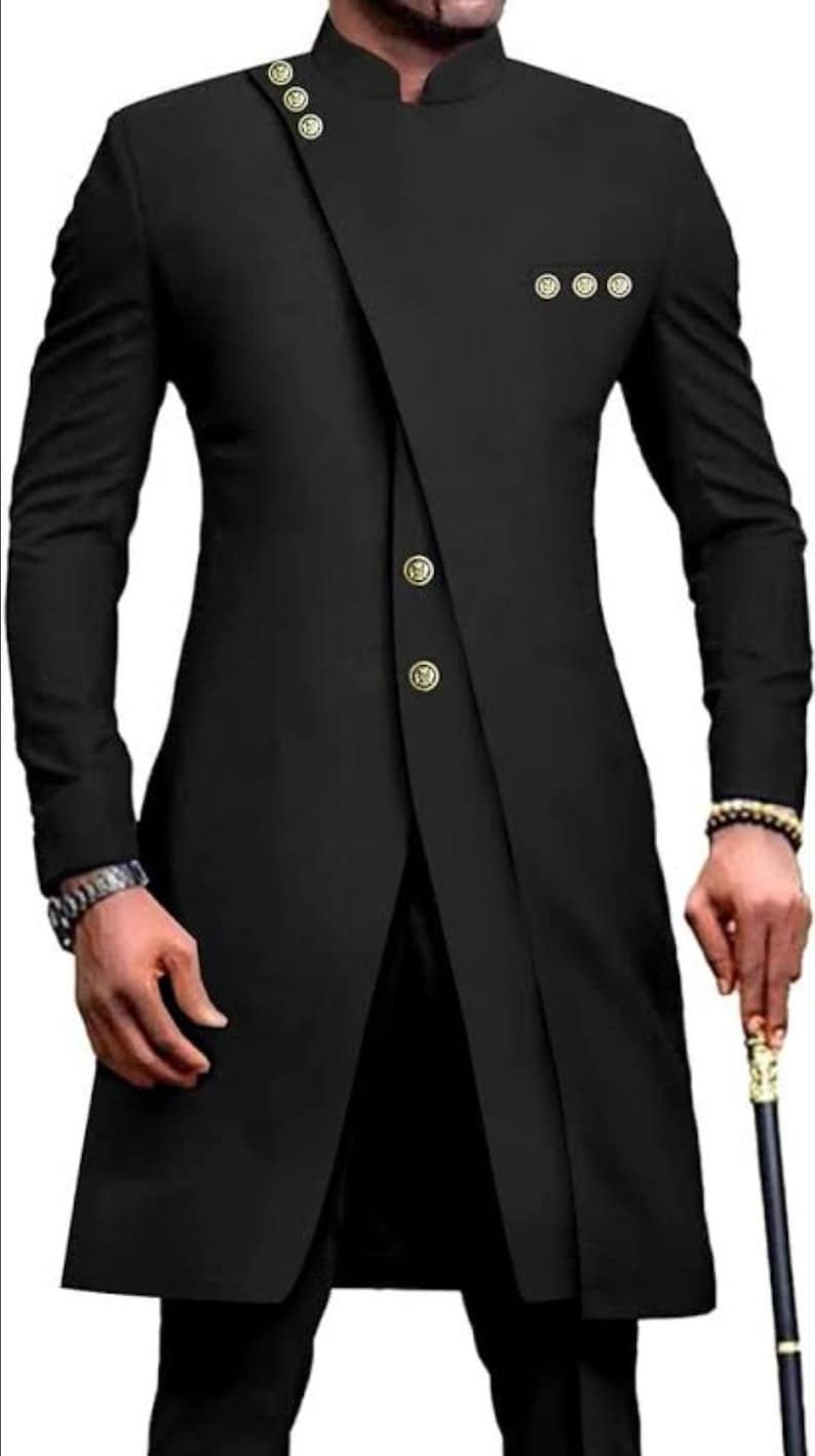 May include: A black long-sleeved suit jacket with a mandarin collar and gold buttons. The jacket has a unique asymmetrical design with a single button closure on the front.