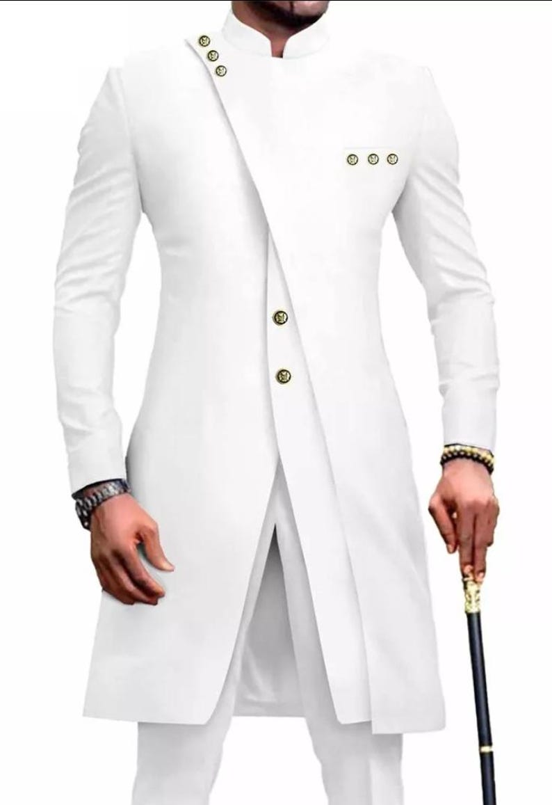 May include: A white long-sleeved suit with a mandarin collar and gold buttons. The suit has a unique asymmetrical design with a long, flowing front panel.