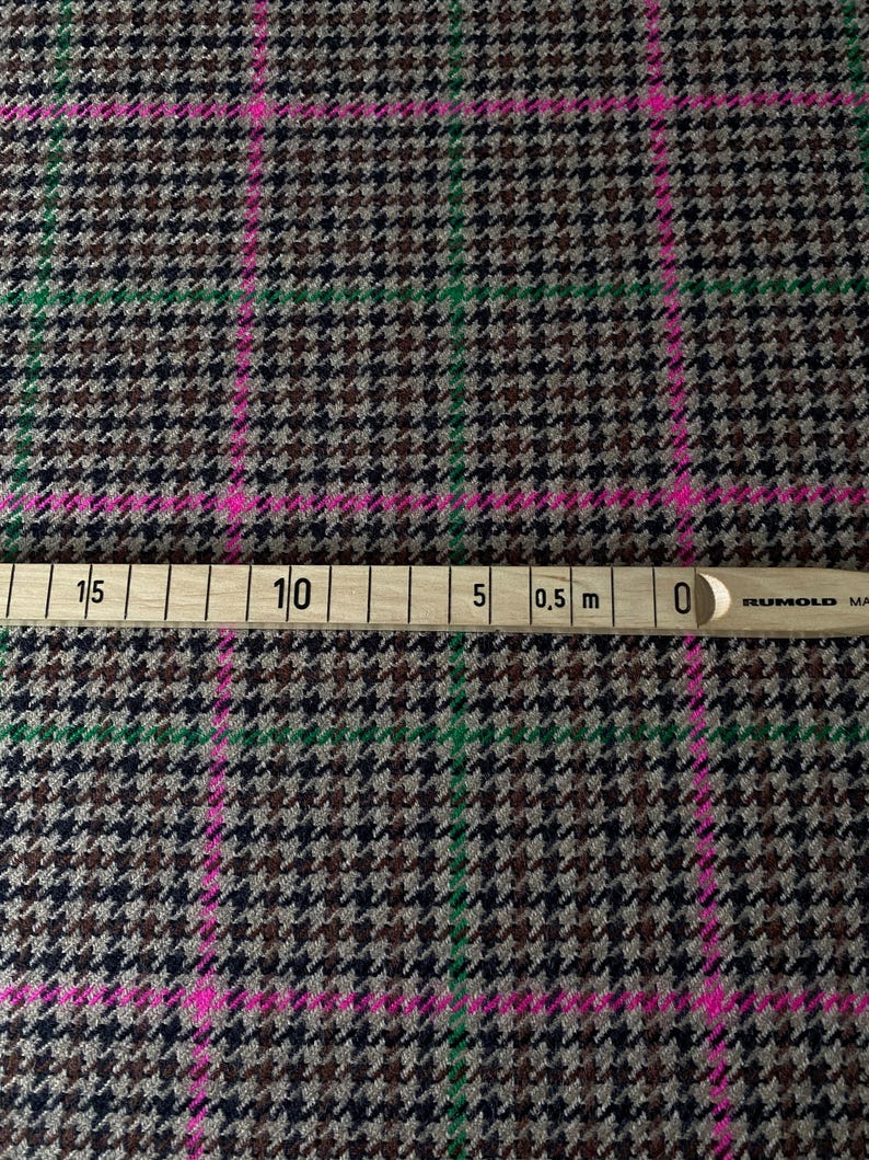 May include: Brown, black, and green houndstooth fabric with pink and green stripes. A ruler is visible at the bottom of the image with markings in centimeters and inches.