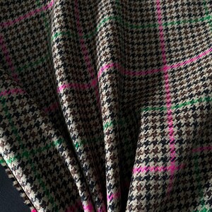 May include: Brown, black, and green houndstooth fabric with pink stripes. The fabric is folded and has a soft, textured feel.