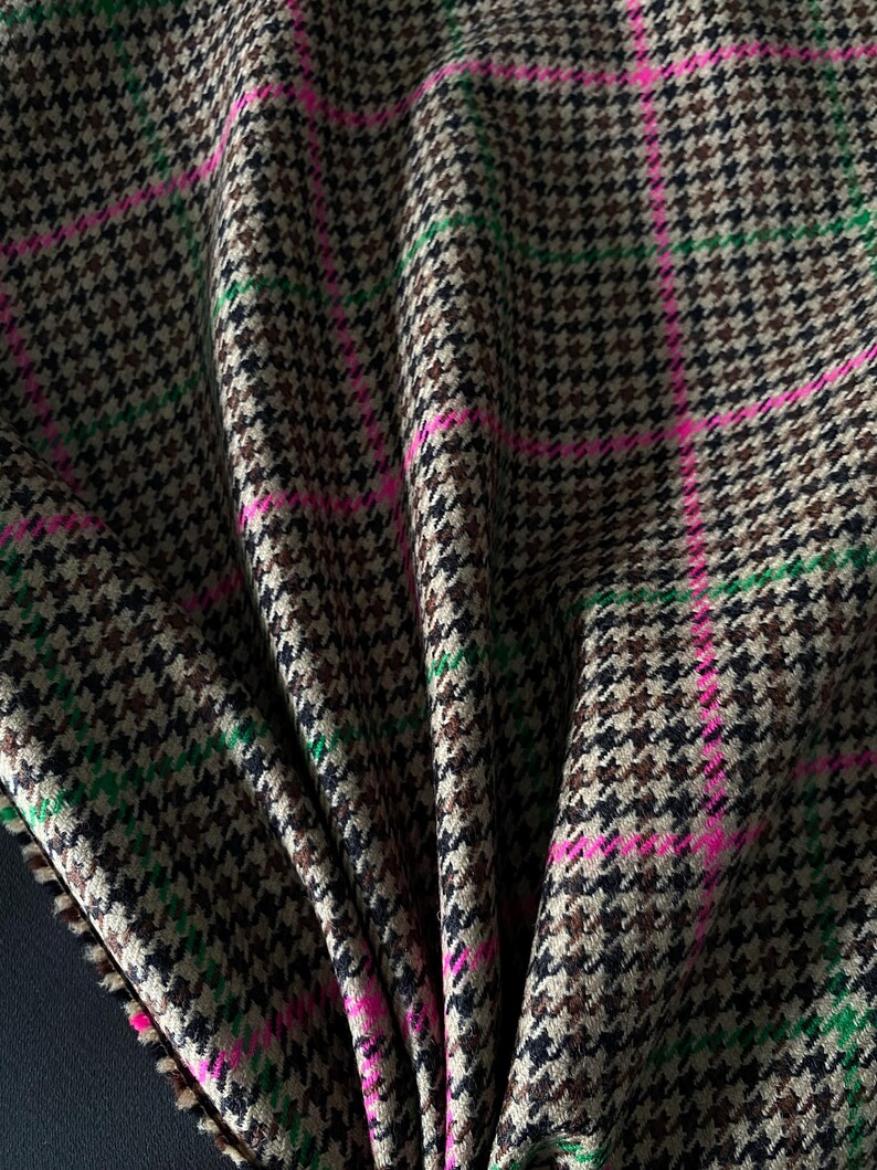 May include: Brown, black, and green houndstooth fabric with pink stripes. The fabric is folded and has a soft, textured feel.