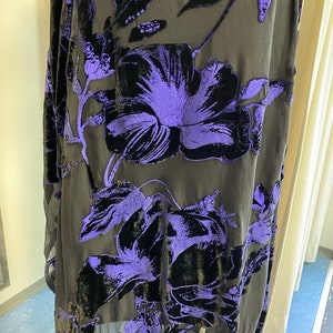 May include: Black sheer fabric with a purple floral pattern. The fabric is made of velvet and has a soft, luxurious feel.