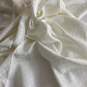 Puede incluir: Tela blanca con un sutil patr&oacute;n en relieve. La tela es suave y se drapeja maravillosamente.