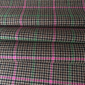 May include: Brown, black, and green houndstooth fabric with pink stripes. The fabric has a woven texture.