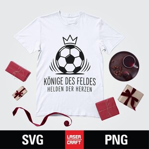 May include: White t-shirt with a black graphic of a soccer ball wearing a crown, with the text "K&Ouml;NIGE DES FELDES HELDEN DER HERZEN". The image includes wrapped gifts and the words "SVG" and "PNG".