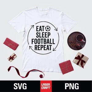 May include: White t-shirt with the text "EAT SLEEP FOOTBALL REPEAT" in black, with a soccer ball graphic. The shirt is surrounded by red wrapped gifts, a dark brown plate with a cup, and a red ribbon.