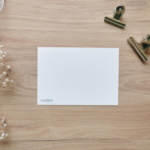 Puede incluir: Una tarjeta blanca en blanco con el texto "Small Talk" impreso en la esquina inferior izquierda. La tarjeta est&aacute; sobre una superficie de madera marr&oacute;n claro.