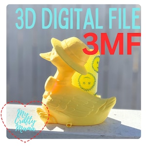 Può includere: Un'anatra gialla stampata in 3D con un cappello, con il testo "3D DIGITAL FILE 3MF" in blu e rosso. L'anatra è seduta su una superficie bianca. L'immagine include anche il testo "My Crafty Mama" in un design a forma di cuore.