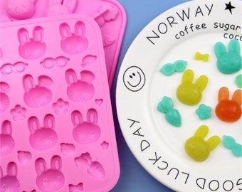 May include: Pink silicone mould with 15 bunny-shaped cavities and a few carrot and bowtie shapes. The mould measures 18.6 cm by 14.1 cm by 1.7 cm. A white plate with the text "GOOD LUCK DAY NORWAY coffee sugar coco" is shown with yellow, orange, and green bunny-shaped sweets.