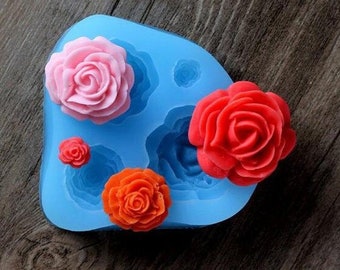 Può includere: Uno stampo in silicone blu con cinque diverse forme di rose. Lo stampo è progettato per realizzare decorazioni per torte o altri dolcetti commestibili.