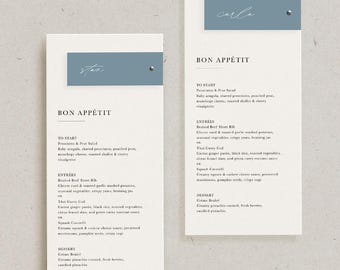 Może przedstawiać: Dwa eleganckie karty menu weselnego o minimalistycznym designie. Każda karta posiada jasnoniebieski baner z imieniem w kursywie i srebrnym ćwiekiem. Tekst "BON APPÉTIT" jest wyświetlany w widocznym miejscu.