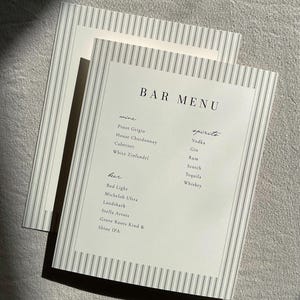 May include: Two bar menus with a white background and gray pinstripes. The top menu reads "BAR MENU" with lists of wines, spirits, and beers. The wine list includes Pinot Grigio, Cabernet, and White Zinfandel. The beer list includes Bud Light and Michelob Ultra.