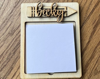 May include: Wooden memo board with a pencil design and the name "Becky" written on it. The board has a white note pad attached to it.