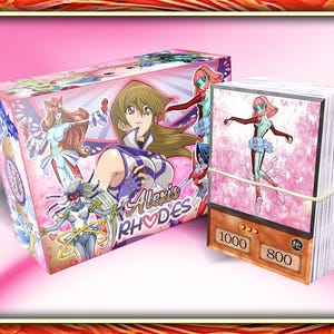 Puede incluir: Una caja de juego de cartas coleccionables rosa y blanca con el texto "Alexis Rhodes" en la parte delantera. La caja presenta ilustraciones de personajes de anime. La caja está junto a una pila de cartas coleccionables con un fondo rosa y blanco y el texto "1000" y "800" en la parte delantera.