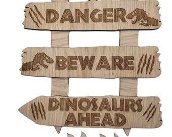 May include: Wooden sign with the words "DANGER", "BEWARE", and "DINOSAURS AHEAD" carved into it. The sign has a dinosaur theme, with dinosaur footprints and dinosaur illustrations. The sign is made of light brown wood.