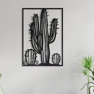 Puede incluir: Arte de pared de metal negro con la silueta de un cactus grande con dos cactus m&aacute;s peque&ntilde;os en primer plano.