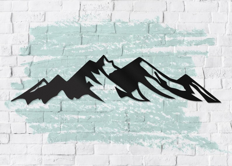 May include: Black metal silhouette of a mountain range against a white brick wall with a light blue painted background.