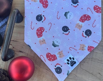 May include: Pink Christmas cat bandana with a white paw print logo and a variety of festive designs including cats wearing Santa hats, candy canes, and snowflakes.