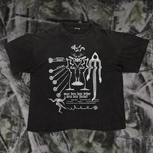 May include: Black t-shirt with a white graphic design featuring skeletal figures, abstract shapes, and text. The text includes phrases like "where two streams of thought collide" and "we've been here before, been here forever."