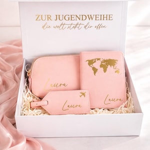 Personalisierte Geschenkbox zur Jugendweihe für Mädchen mit rosa Reiseset bestehend aus Kosmetiktasche, Reisepasshülle und Kofferanhänger in Goldschrift, stilvoll in weißer Box mit hellem Hintergrund und zartrosa Seidentuch inszeniert