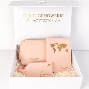 Personalisierte Geschenkbox zur Jugendweihe mit rosa Reise-Set aus Kosmetiktasche, Reisepasshülle und Kofferanhänger mit Name Laura in Gold, dekorativ in weißer Box arrangiert